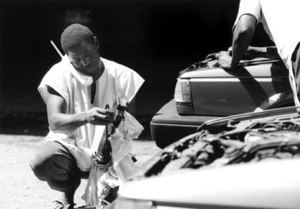 Oumar entre le téléphone et une voiture